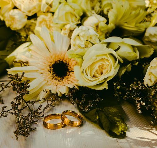 Free Golden wedding rings with a bouquet of white roses, perfect elegance. Stock Photo