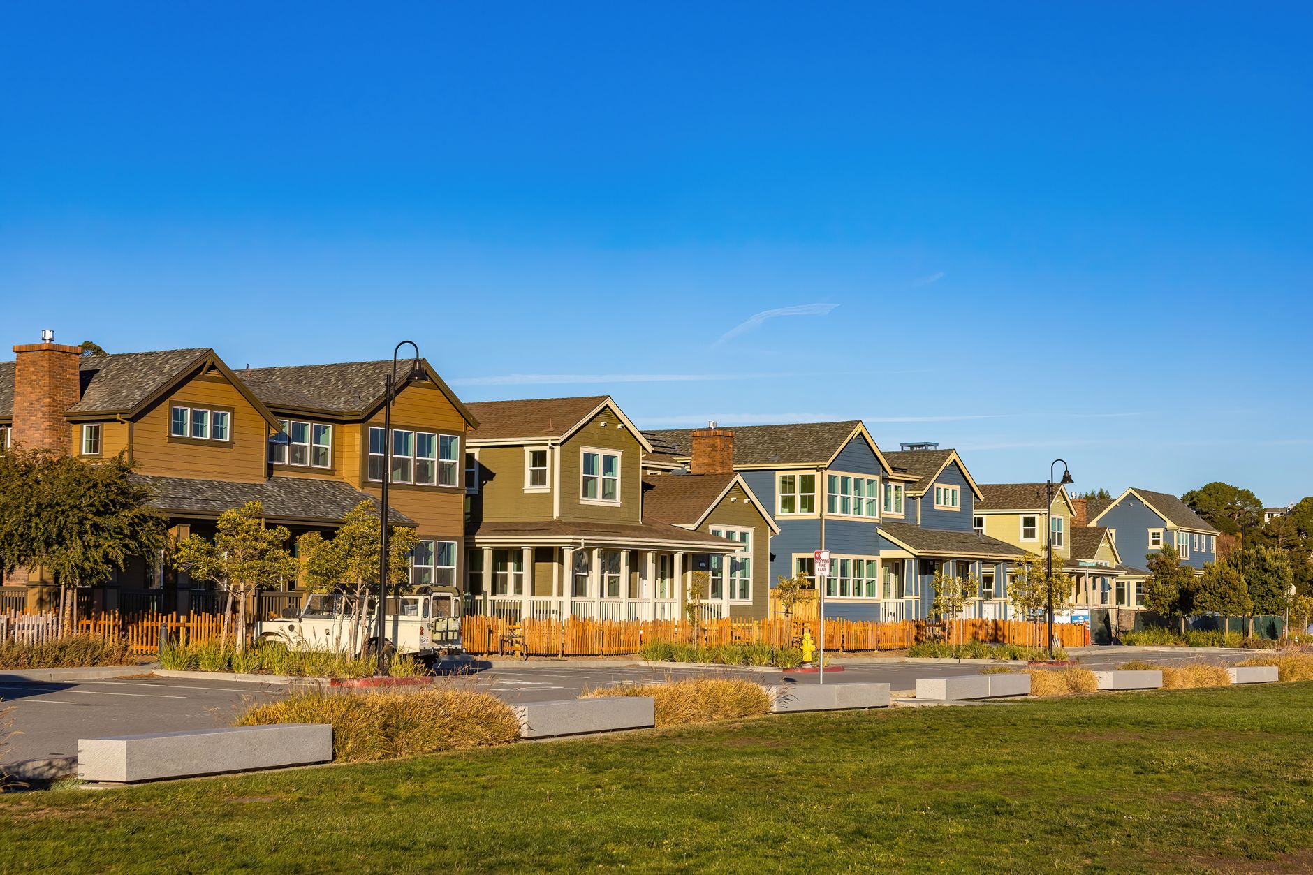 A picturesque view of suburban homes in a quiet neighborhood under a clear blue sky.