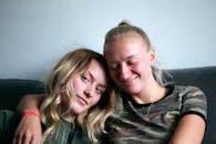 两个女人在沙发上微笑着，享受着宁静的时光，展现了亲情与友谊