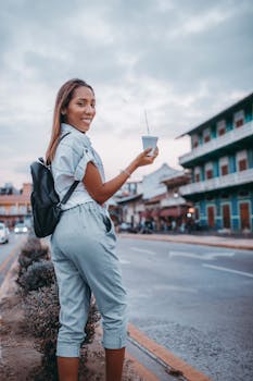 Woman sipping a drink on a street in Panama City, embracing a relaxed urban vibe.