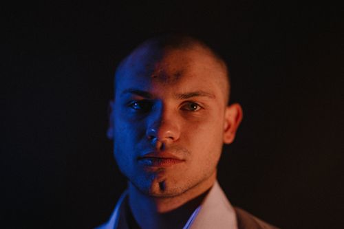 Free Artistic headshot capturing a man's face in contrasting blue and orange light. Stock Photo