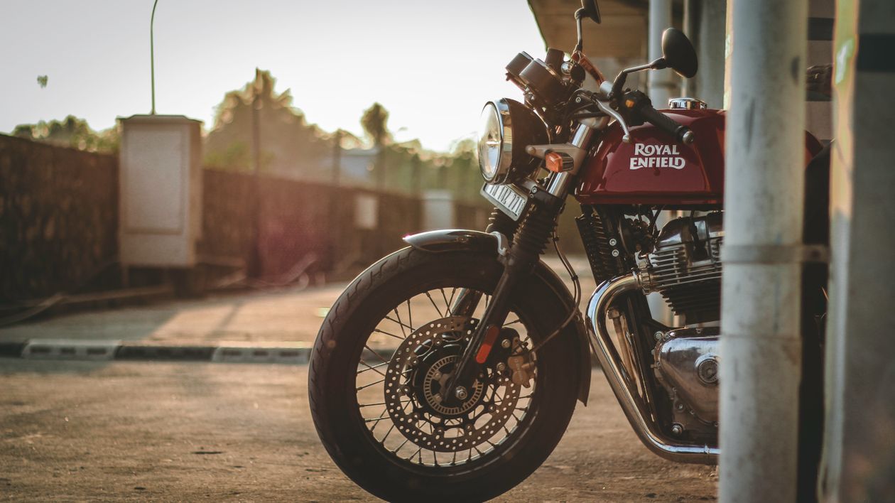 Free Side view of a parked Royal Enfield motorcycle during sunset outdoors. Stock Photo