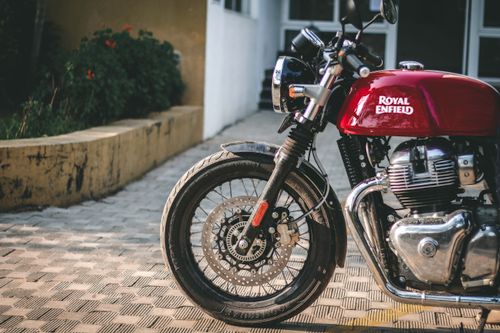 Free A detailed shot of a Royal Enfield motorcycle parked outdoors, showcasing its front wheel and engine. Stock Photo