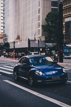 一辆蓝色大众甲壳虫行驶在圣保罗保利斯塔大道的城市场景中