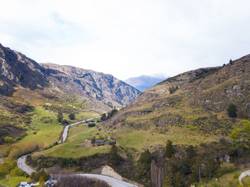 Free Breathtaking aerial view of mountainous landscape in New Zealand, showcasing lush green valleys and winding roads. Stock Photo