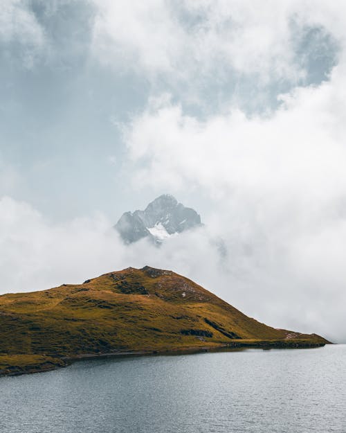 Green Hill near Water in Fog