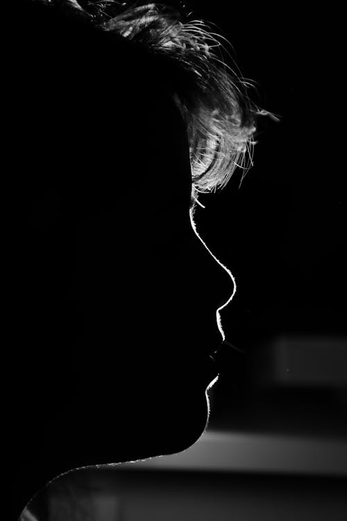 Side View of a Person in the Dark Room 