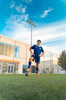 Teen soccer player poses confidently on football field in Bahrain.