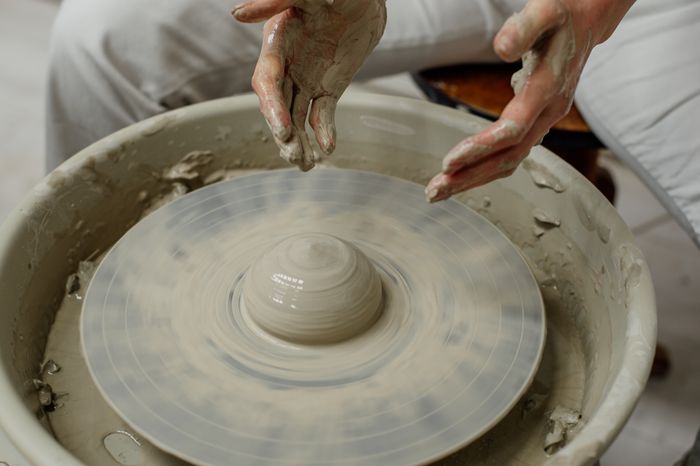 Hands shaping clay on a potters wheel — photo by Anastasia Lashkevich on Pexels