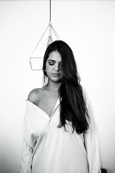 Black and white portrait of a woman in a loose white shirt — photo by Letícia Rodrigues on Pexels