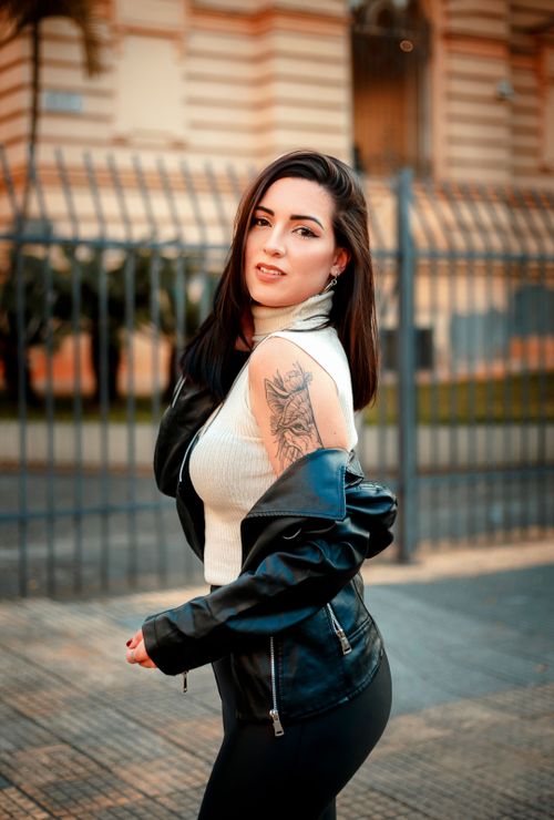 Free Stylish woman in black leather jacket and tattoo, posing on a city street. Stock Photo