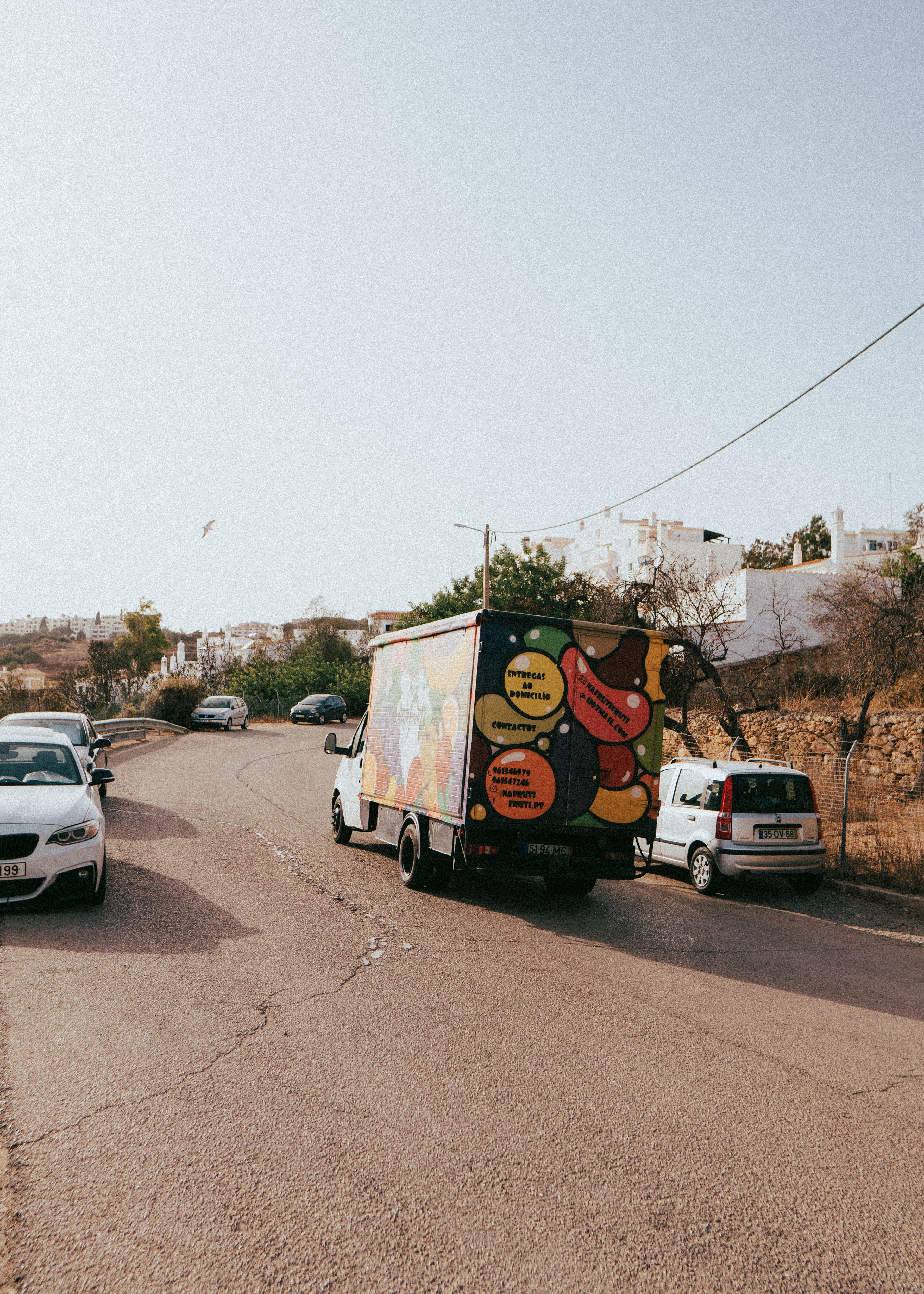 A vibrant truck driving through a sunny street in Albufeira, Portugal.