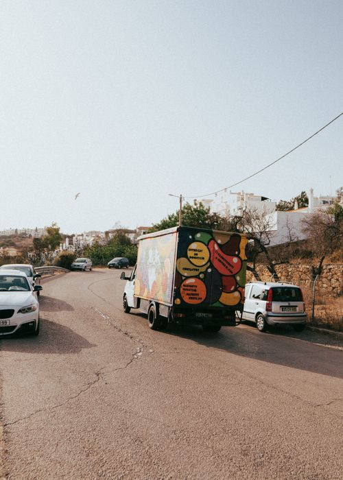 Free A vibrant truck driving through a sunny street in Albufeira, Portugal. Stock Photo