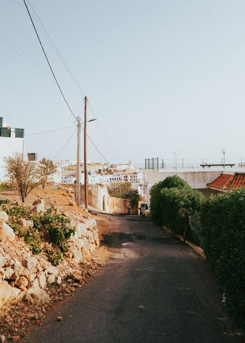 Free Charming dirt road leading to Albufeira, Portugal, with views of town and greenery. Stock Photo