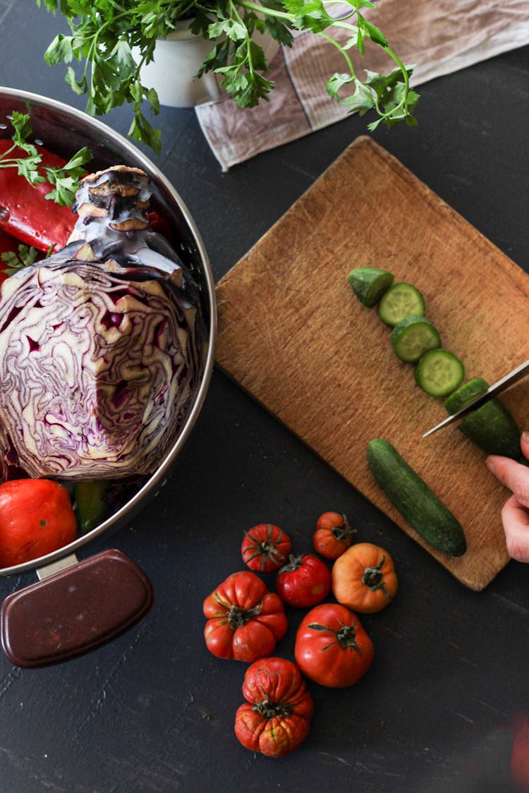 Overhead Shot Of A Person's Hand Slicing A Cucumber