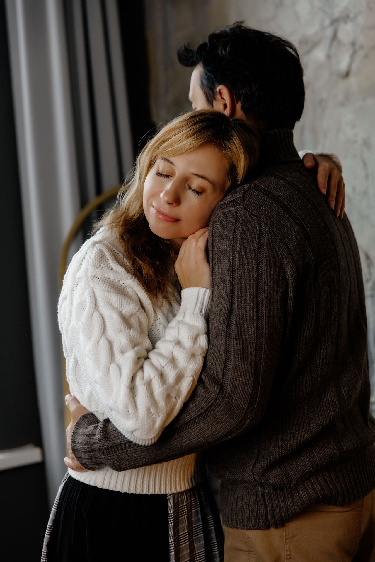 A loving couple shares an intimate embrace indoors