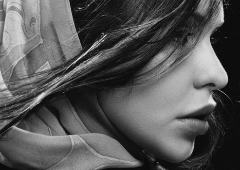 Close-up black and white portrait of a woman with a shawl, highlighting elegance.