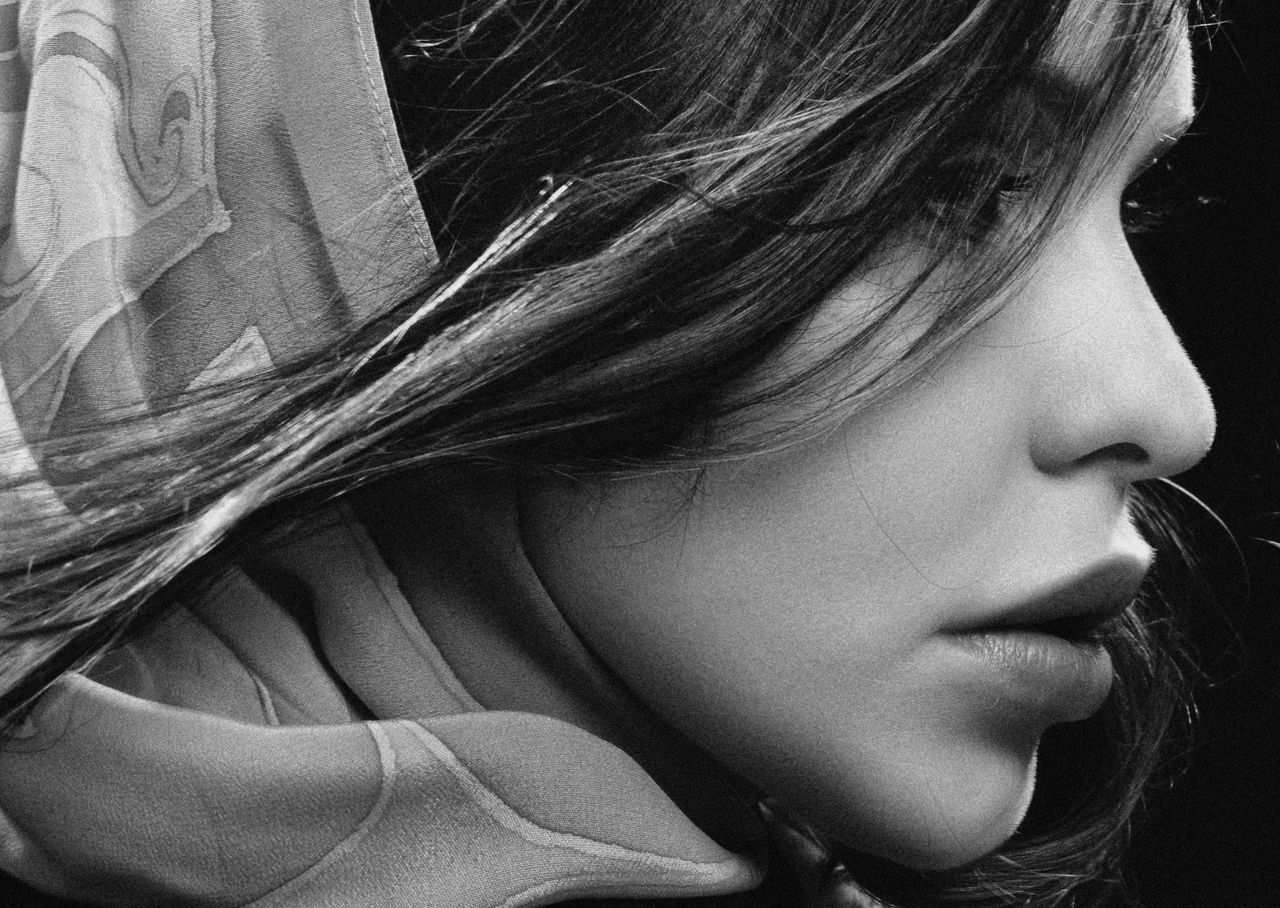 close up black and white portrait of a woman with a shawl highlighting