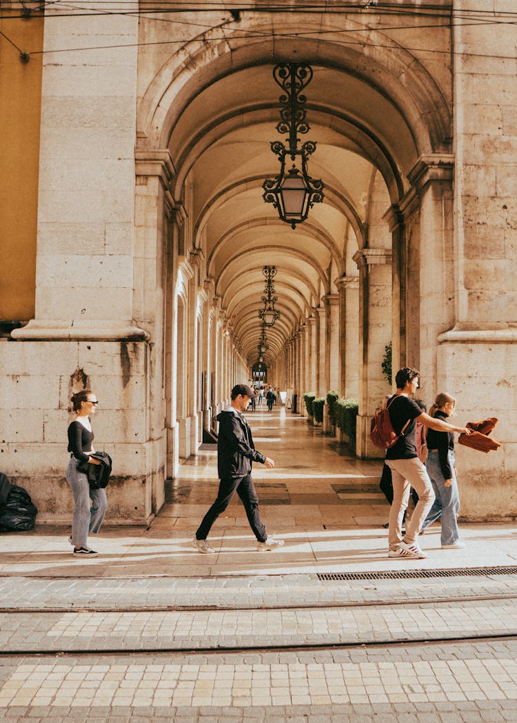 People Passing By An Old Concrete Building