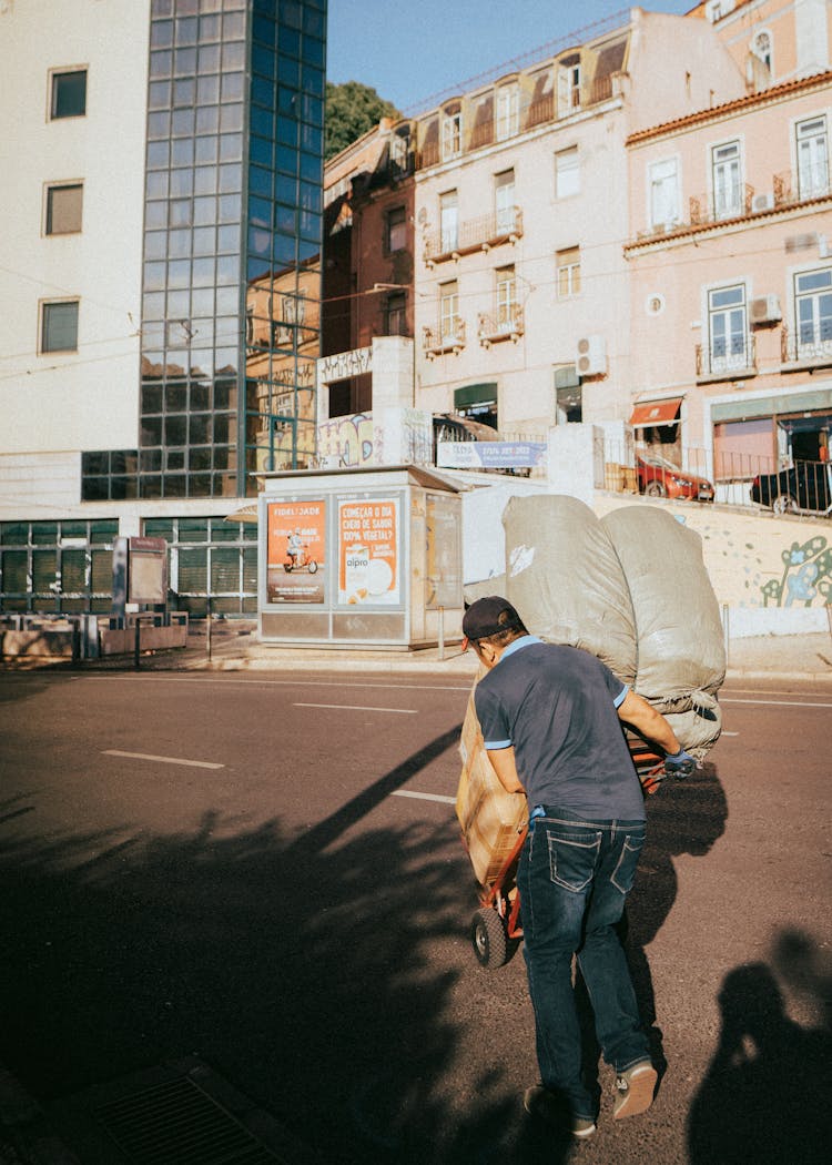 A Man Pushing A Cart At Work