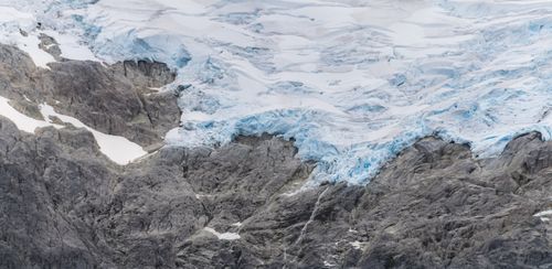 Free Stunning view of a glacier with surrounding rugged rocks in Patagonia. Stock Photo
