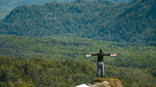 Free A man with outstretched arms taking in the scenic mountain landscape. Stock Photo