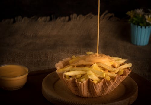 Sauce Being Poured on French Fries 