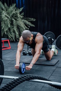 Man working out with ab wheel in Mexico City gym, focusing on a healthy lifestyle and fitness.