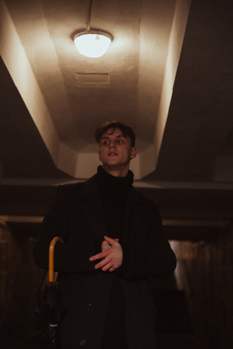 Low Angle Shot Of Man In Black Coat With Umbrella 