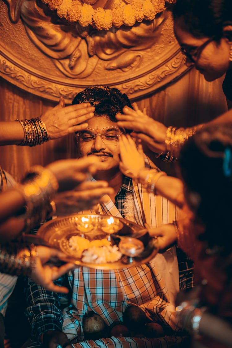 People Hands Around Man Face On Ceremony