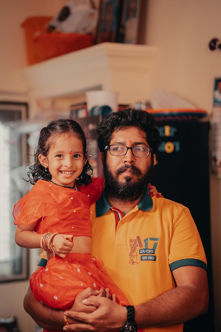 A Man In A Yellow Polo Shirt Carrying A Girl In A Red Crop Top