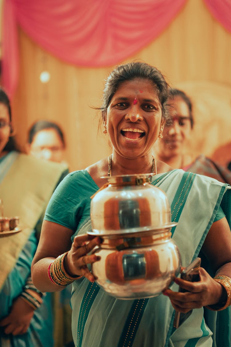 A Woman Holding A Metal Pot