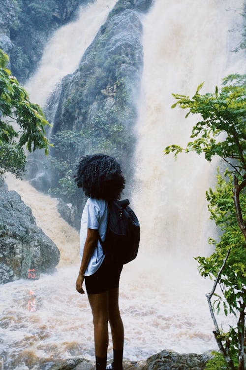 Free Backpacker Looking at a Waterfall  Stock Photo