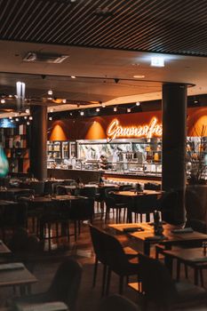 Warm and inviting interior of a stylish restaurant with empty tables and modern decor.