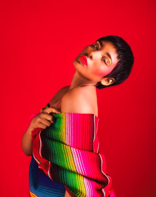 Young Woman in a Colorful Outfit Posing in Studio on Red Background 