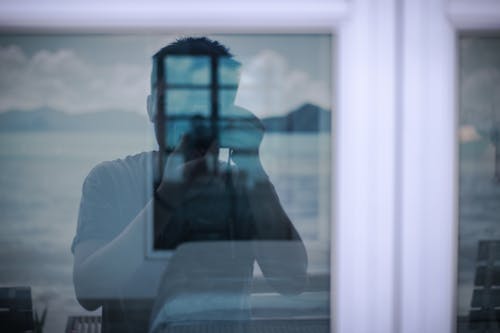 Free Man Taking Photo of a Windowpane Stock Photo