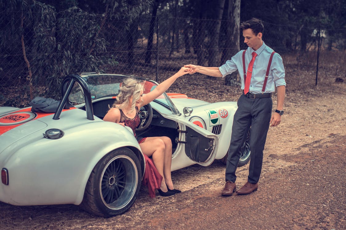 Man Helping Woman Stand from Car