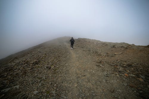 Free A Person Walking on the Mountain with Fog  Stock Photo