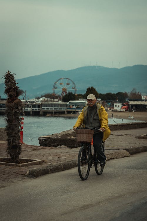 Man in Yellow Jacket Riding a Bike 