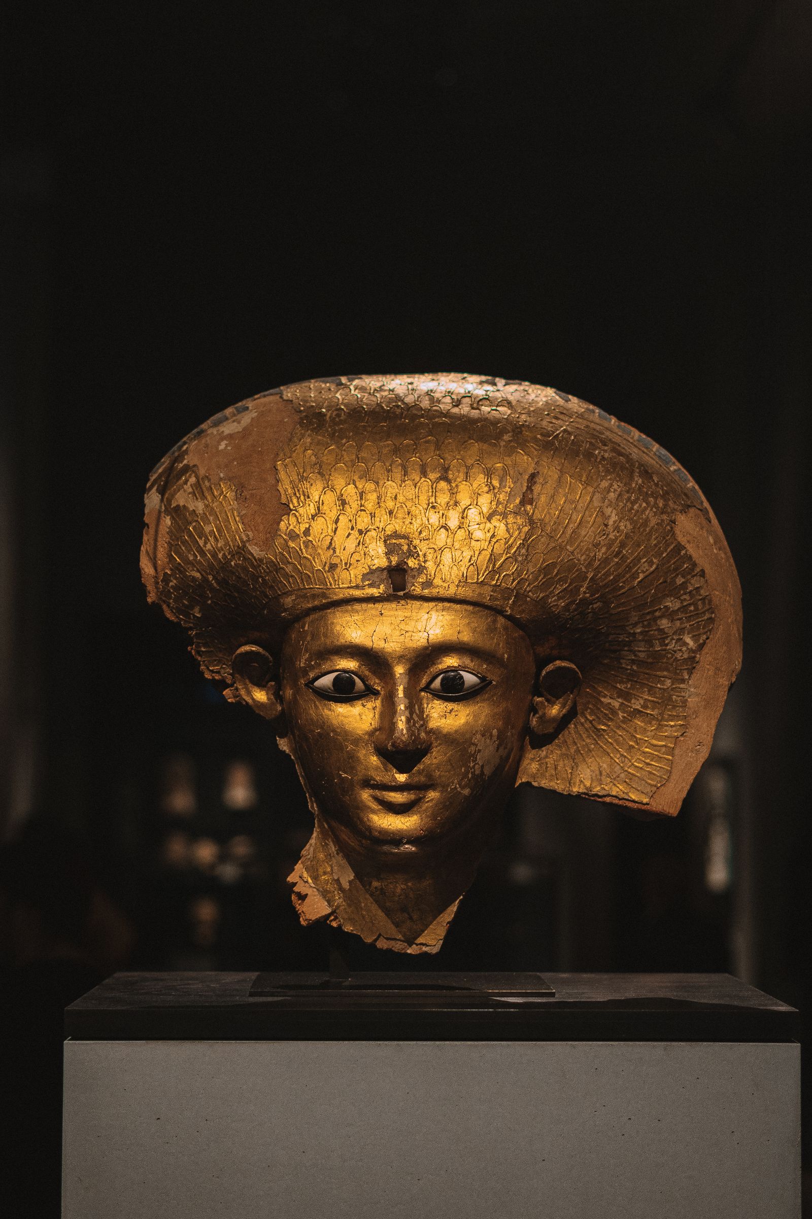 Golden Tutankhamun treasures glowing in a darkened gallery