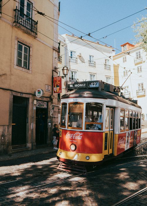 Free Charming old tram making its way through the sun-drenched streets of Lisbon, Portugal. Stock Photo
