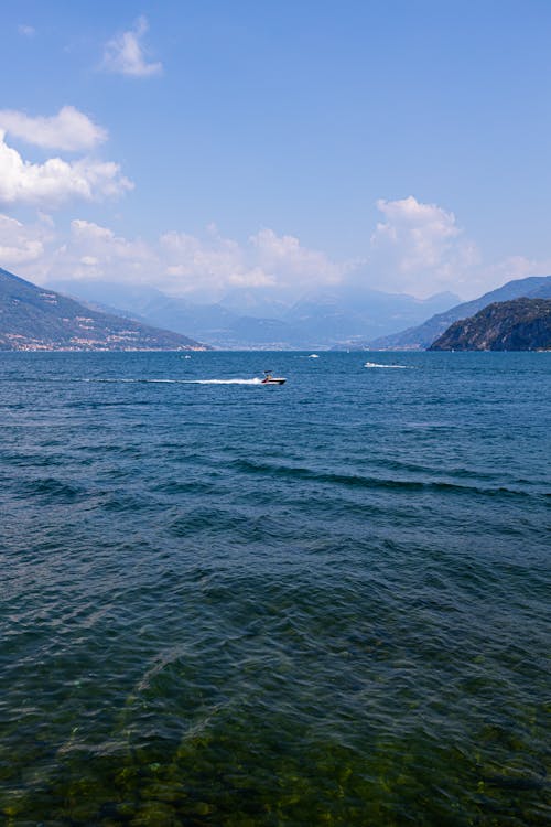 Motorboat Sailing on Lake Como Surrounded by Alps