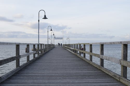People Standing on a Wooden Pier in Distance 