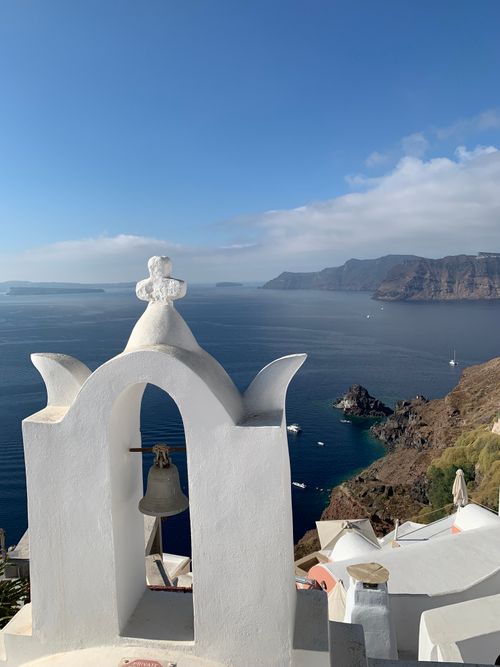 Free Captivating view of a white bell tower in Oia, Santorini with a backdrop of the Aegean Sea. Stock Photo