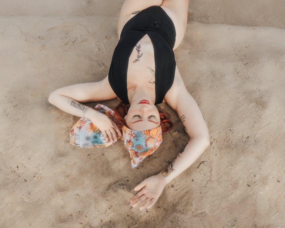 Woman Wearing Black Swimsuit Lying on a Beach 