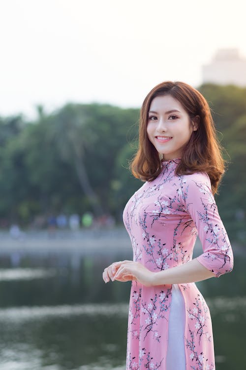 Free Woman Standing In Front Of Body Of Water Stock Photo