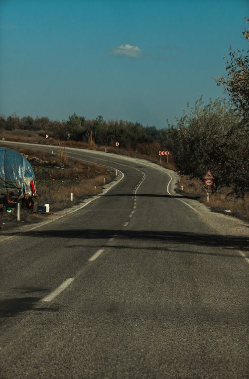 View of an Asphalt Road in the Countryside under Blue Sky 