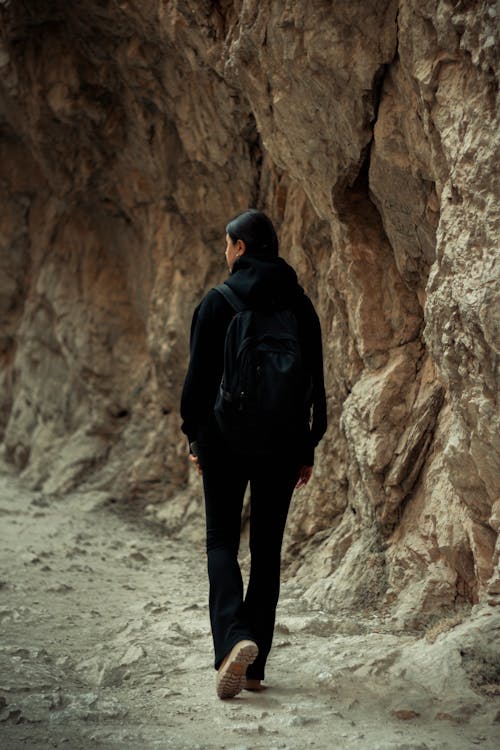 A Woman in Black Hoodie Walking on Rocky mountain