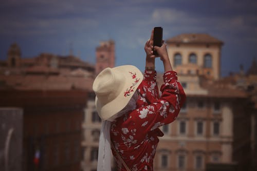 Woman Wearing Hat Taking Photo with a Smartphone