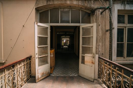 Vintage building exterior with open doors leading to a nostalgic hallway.